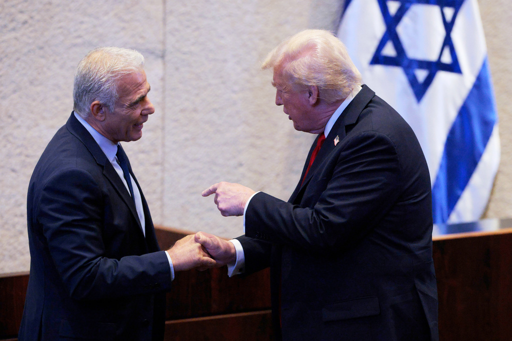 President Donald Trump interacts with Israeli opposition leader Yair Lapid during his appearance before the Knesset, Israel's parliament, Monday, Oct. 13, 2025, in Jerusalem. (Chip Somodevilla/Pool via AP)