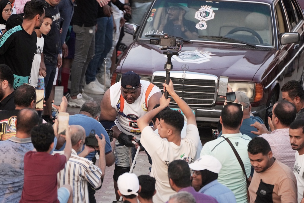 Egyptian wrestler Ashraf Mahrous, also known by his nickname Kabonga, attempts to pull 20 vehicles at Al Safaa Club in 10th of Ramadan City, outside Cairo, Egypt, Friday, Aug. 1, 2025. (AP Photo/Amr Nabil)