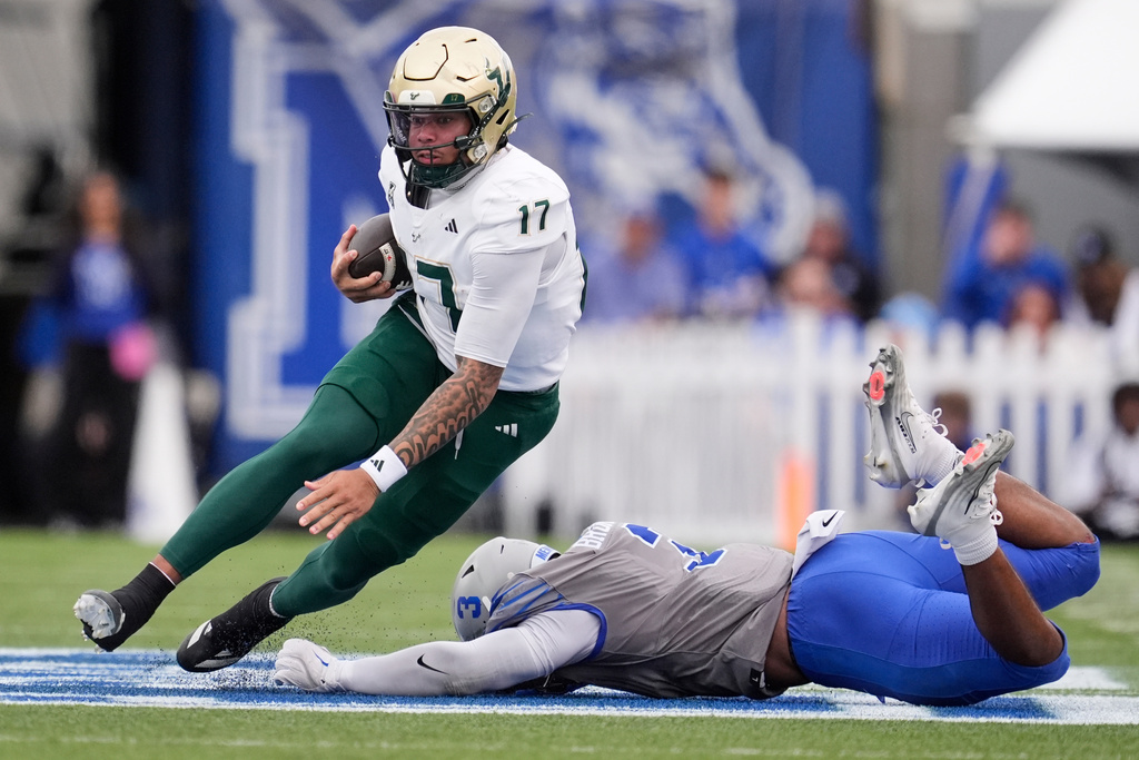 South Florida quarterback Byrum Brown (17) runs the ball past Memphis linebacker Sam Brumfield, right, during the first half of an NCAA college football game Saturday, Oct. 25, 2025, in Memphis, Tenn. (AP Photo/George Walker IV)