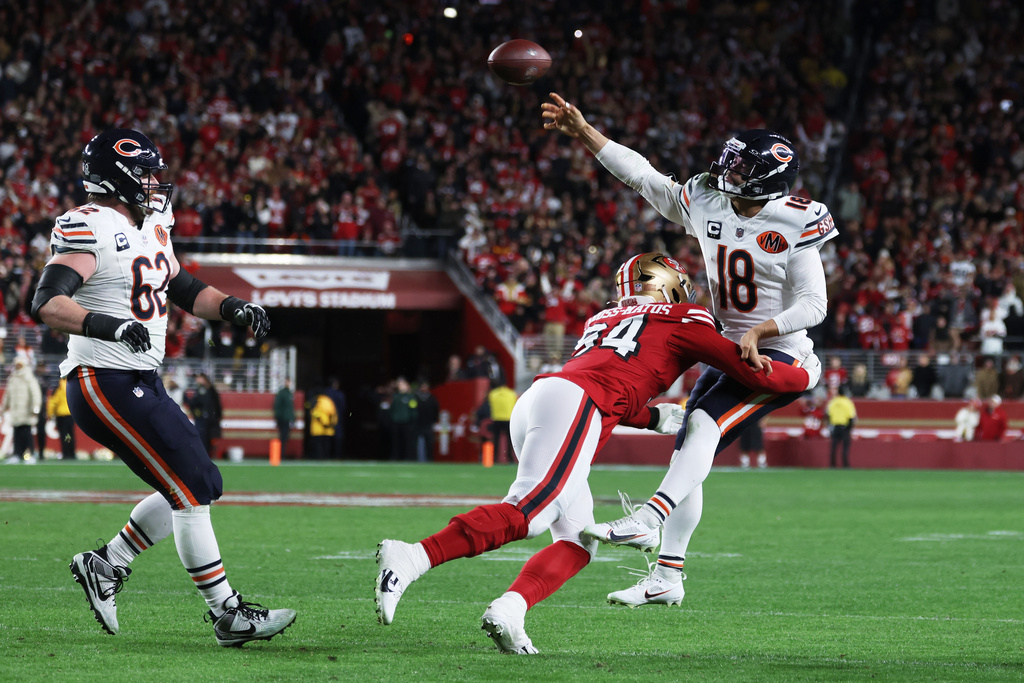 Chicago Bears quarterback Caleb Williams (18) passes while pressured by San Francisco 49ers defensive end Yetur Gross-Matos (94) on the final play of the second half of an NFL football game in Santa Clara, Calif., Sunday, Dec. 28, 2025. (AP Photo/Jed Jacobsohn)