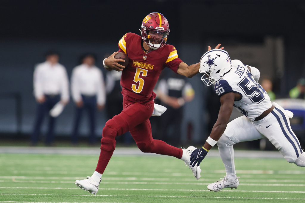 Washington Commanders quarterback Jayden Daniels, left, runs with the ball as Dallas Cowboys linebacker Shemar James tries to stop him during the first half of an NFL football game Sunday, Oct. 19, 2025, in Arlington, Texas. (AP Photo/Gareth Patterson)