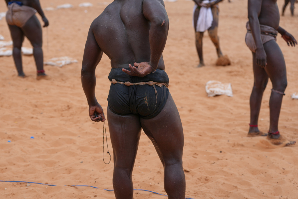 Wrestlers wait to compete at the national wrestling arena in Dakar, Senegal, Sunday, March 29, 2026. (AP Photo/Misper Apawu)