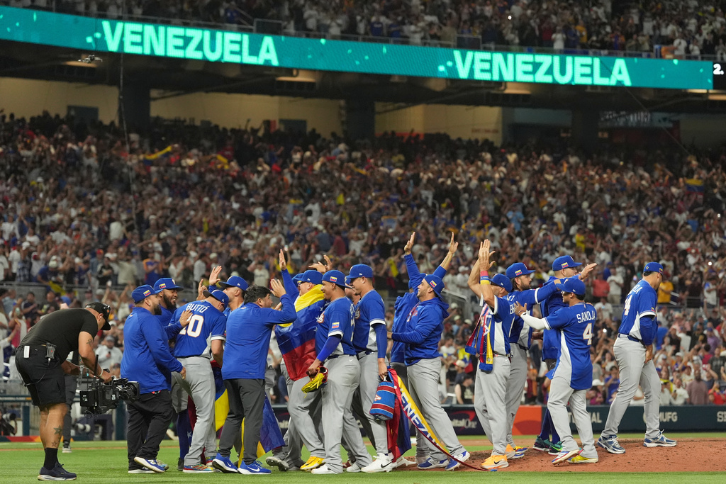 The Venezuela team celebrates after defeating Italy at a World Baseball Classic semifinal game, Monday, March 16, 2026, in Miami. (AP Photo/Rebecca Blackwell)