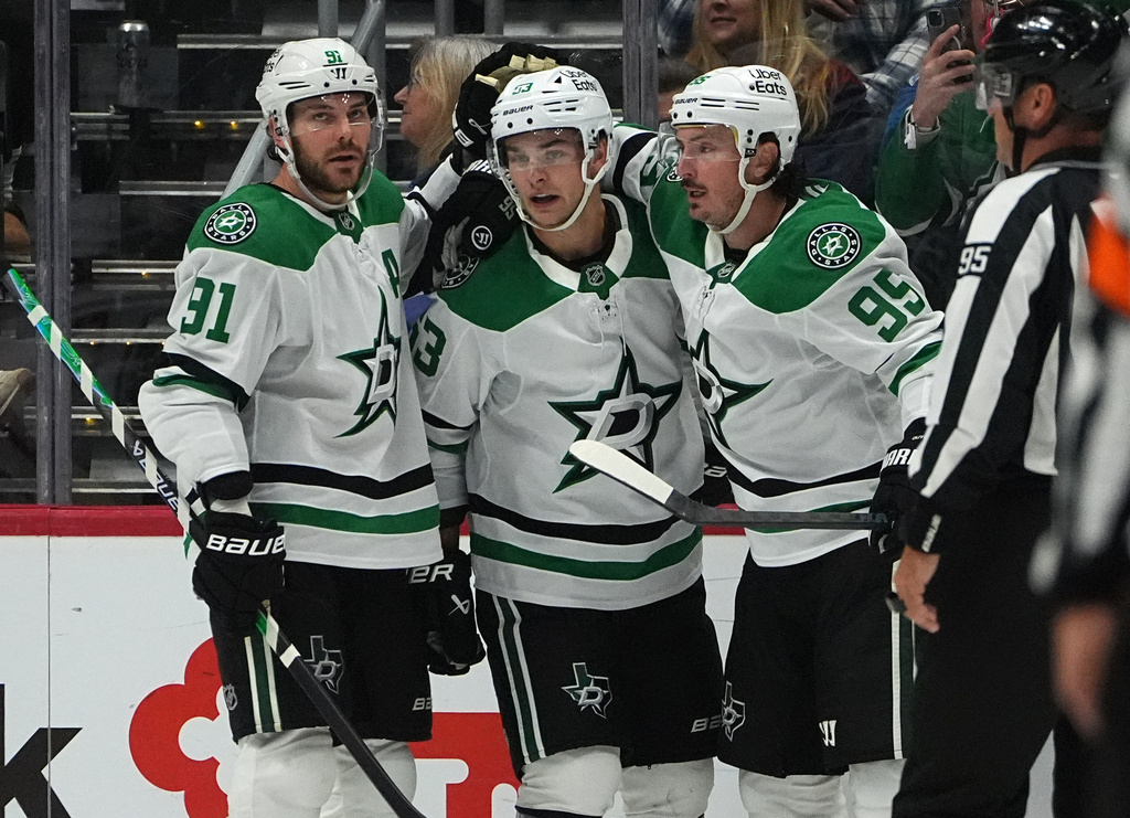 Dallas Stars center Wyatt Johnston, center, is congratulated after scoring a goal by centers Tyler Seguin, left, and Matt Duchene in the third period of an NHL hockey game against the Colorado Avalanche Saturday, Oct. 11, 2025, in Denver. (AP Photo/David Zalubowski)