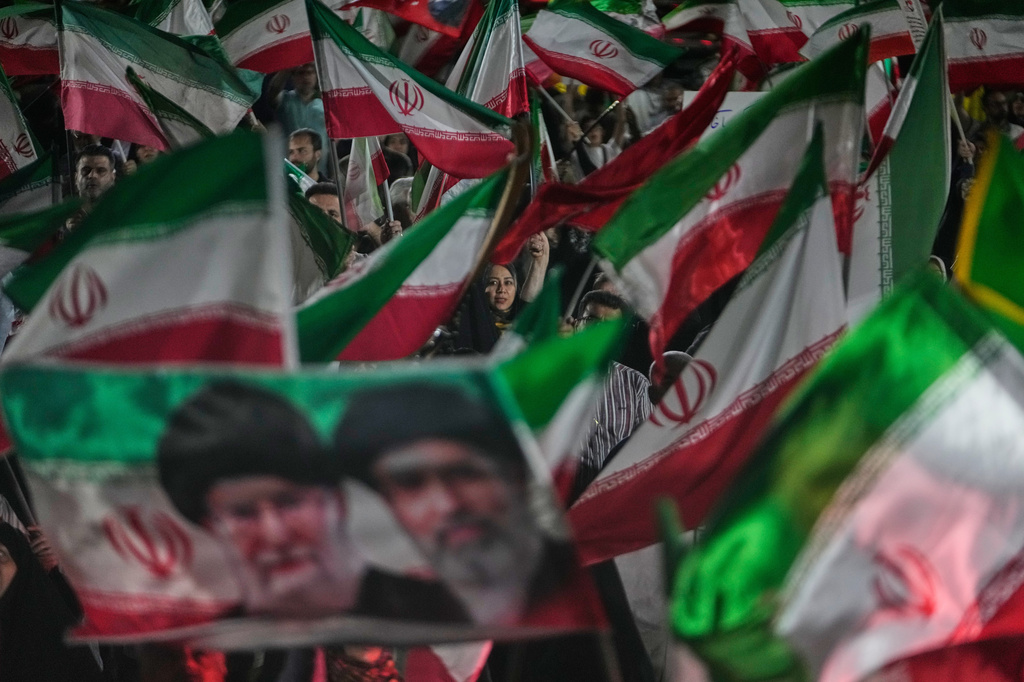Pro-government Iranian demonstrators wave Iranian flags and a portrait of the Supreme Leader Ayatollah Mojtaba Khamenei, right, and his slain father Ayatollah Ali Khamenei in a gathering at a square in Tehran, Iran, Friday, May 29, 2026. (AP Photo/Vahid Salemi)