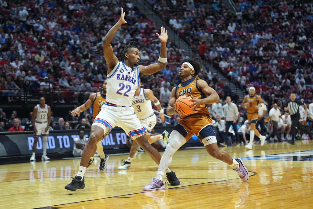 California Baptist guard Dominique Daniels Jr., right, drives to the basket as Kansas guard Darryn Peterson defends during the first half in the first round of the NCAA college basketball tournament Friday, March 20, 2026, in San Diego. (AP Photo/Marcio Jose Sanchez)