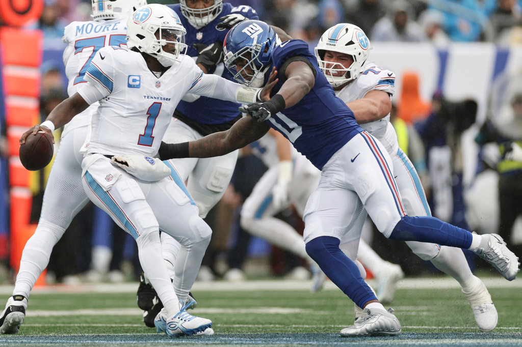 New York Giants linebacker Brian Burns (0) pressures Tennessee Titans quarterback Cam Ward (1) during the first half of an NFL football game in East Rutherford, N.J., Sunday, Sept. 27, 2026. (AP Photo/Adam Hunger)