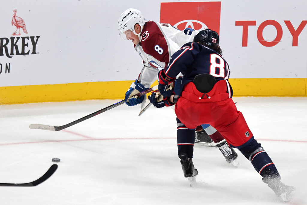 Colorado Avalanche defenseman Cale Makar, left, reaches for the puck in front of Columbus Blue Jackets forward Kirill Marchenko during the third period of an NHL hockey game in Columbus, Ohio, Thursday, Oct. 16, 2025. (AP Photo/Paul Vernon)