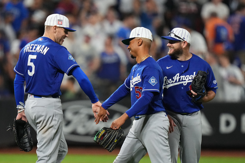 Los Angeles Dodgers' Freddie Freeman (5) celebrates with teammates Mookie Betts (50) and Max Muncy after a baseball game against the New York Mets Saturday, July 25, 2026, in New York. (AP Photo/Frank Franklin II)