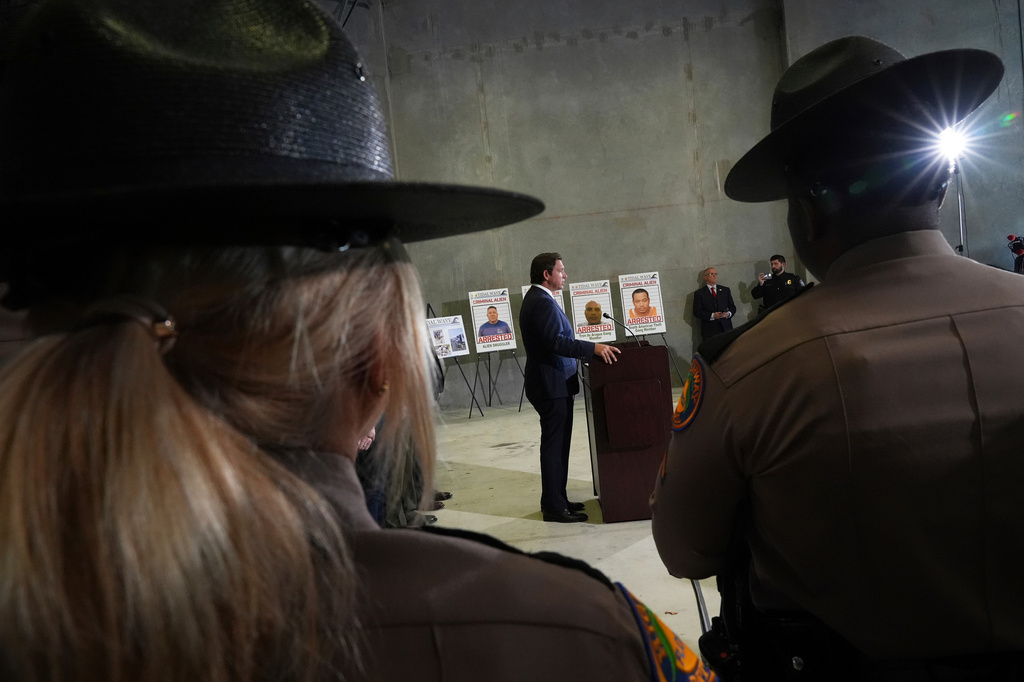 FILE - Florida Highway Patrol officers listen to Gov. Ron DeSantis speak during a press conference about a recent immigration enforcement operation, at the South Florida office of U.S. Immigration and Customs Enforcement and Enforcement and Removal Operations, May 1, 2025, in Miramar, Fla. (AP Photo/Rebecca Blackwell, File)