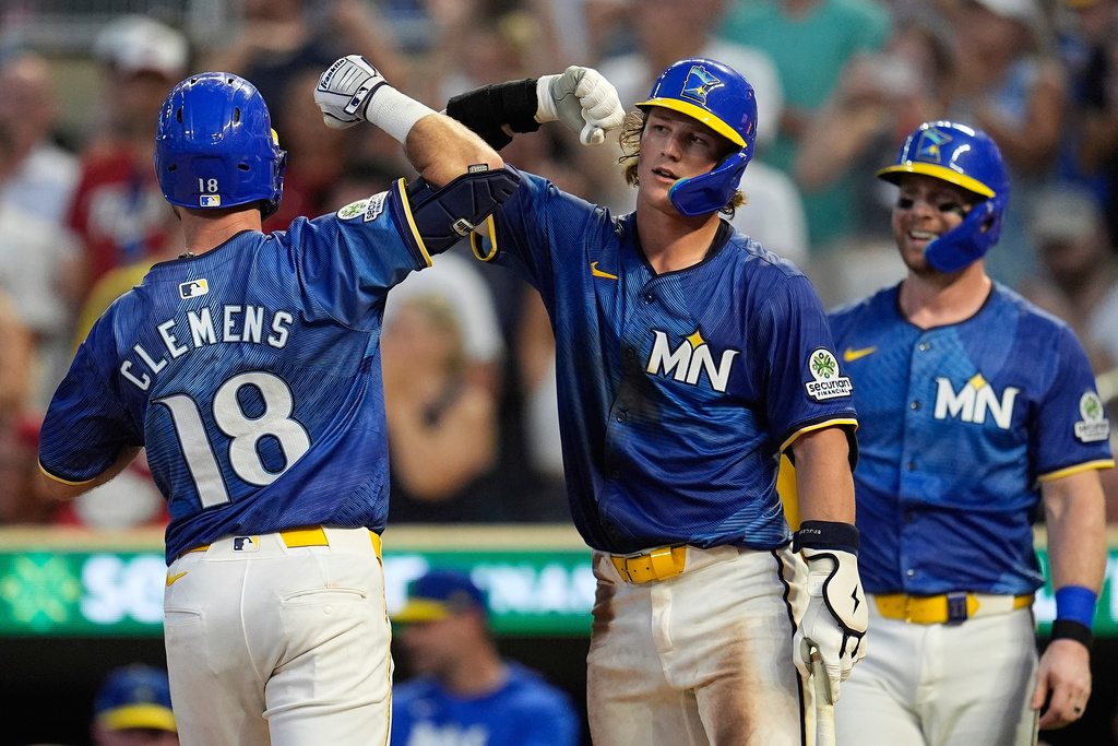 Minnesota Twins' Kody Clemens (18) celebrates with Luke Keaschall (15), center, after hitting a solo home run during the fourth inning of a baseball game against the Kansas City Royals, Friday, Aug. 8, 2025, in Minneapolis. (AP Photo/Abbie Parr)