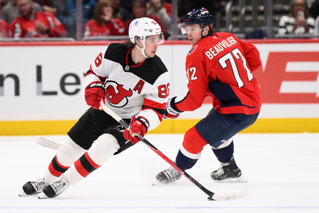 New Jersey Devils center Jack Hughes (86) skates with the puck past Washington Capitals right wing Anthony Beauvillier (72) during the second period of an NHL hockey game Friday, March 20, 2026, in Washington. (AP Photo/Nick Wass)