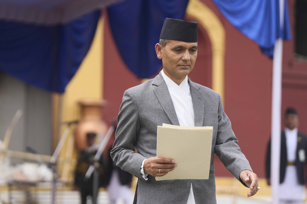 New Home Minister Om Prakash Aryal walks after taking the oath of office by Nepalese President Ram Chandra Poudel, in front of the presidential building vandalized during recent protests, in Kathmandu, Nepal, Monday, Sept. 15, 2025. (AP Photo/Niranjan Shrestha)