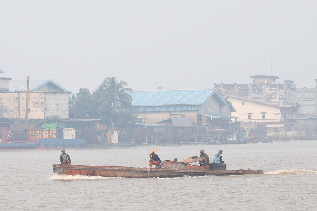 A boat cruises on the Kapuas River as haze from wildfires blankets the city of Pontianak, West Kalimantan, Indonesia, Friday, Aug. 21, 2026. (AP Photo/Stefanus Taman)