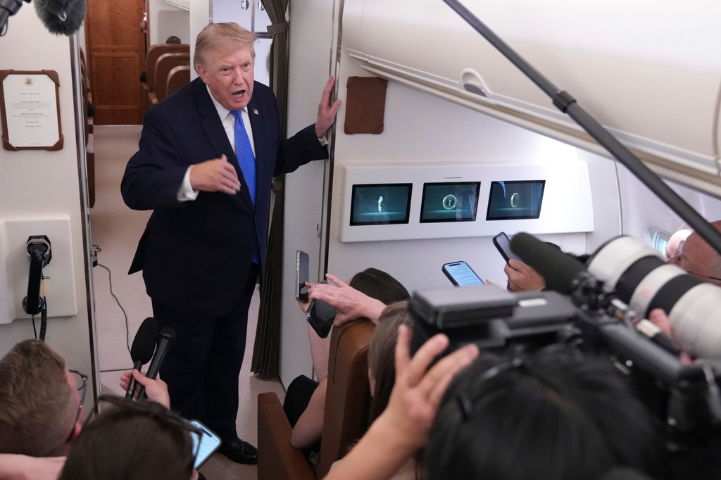 President Donald Trump speaks to reporters onboard Air Force One while returning to the White House, Sunday, Aug. 2, 2026. (AP Photo/Jacquelyn Martin)