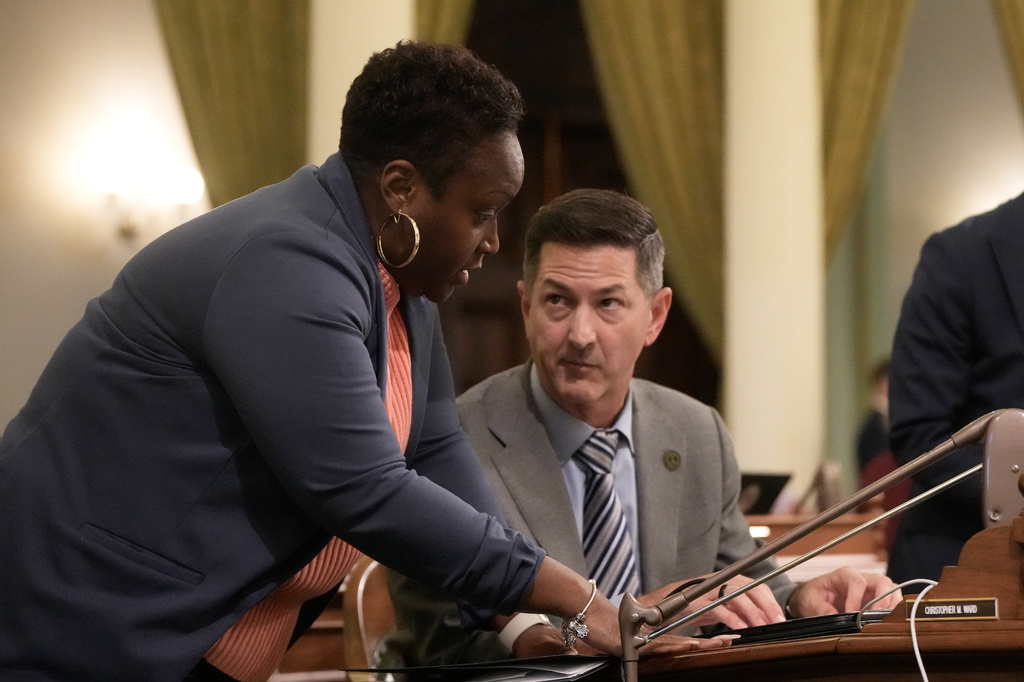Assemblymember LaShae Sharp-Collins, left, talks with Assemblymember Christopher Ward during an Assembly session at the Capitol, Monday, Aug. 31, 2026, in Sacramento, Calif. (AP Photo/Jeff Chiu)
