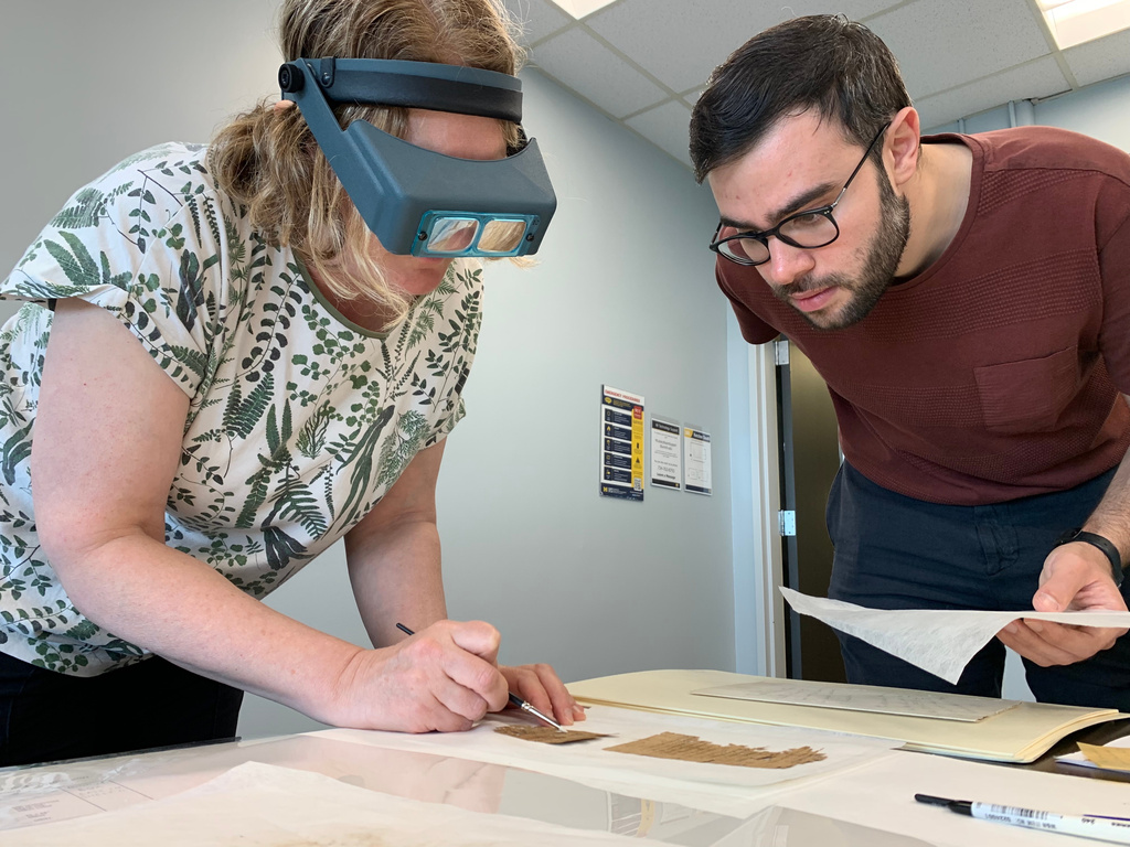 Papyrus Conservation Summer Seminar instructor Marieka Kaye inspects student Mauro Castiello's papyrus fragment and provides him with feedback on his preservation work at the University of Michigan Thursday, Aug. 6, 2026, in Ann Arbor, Mich. (AP Photo/Mike Householder)