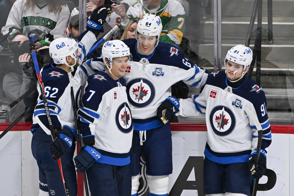 Winnipeg Jets defenseman Logan Stanley, second from right, celebrates with right wing Nino Niederreiter (62), center Vladislav Namestnikov (7) and center Cole Perfetti (91) after scoring against the Minnesota Wild during the second period of an NHL hockey game, Thursday, Jan. 15, 2025, in St. Paul, Minn. (AP Photo/Craig Lassig)