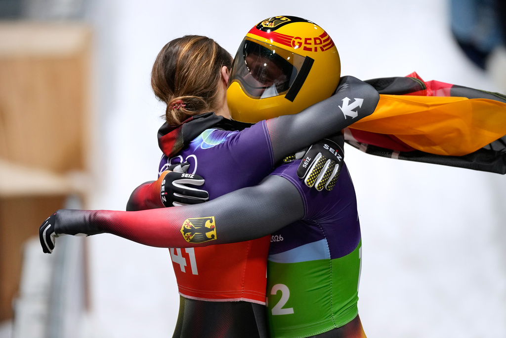 Germany's bronze medalists Christopher Grotheer, right, and Germany's Jacqueline Pfeifer, left, celebrate at the finish during the skeleton mixed team competition at the 2026 Winter Olympics, in Cortina d'Ampezzo, Italy, Sunday, Feb. 15, 2026. (AP Photo/Aijaz Rahi)