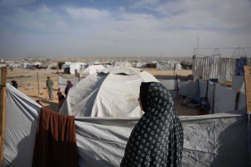Siham Omran, 54, recently returned from Egypt after completing her medical treatment, looks at the tents of displaced people next to her that were set up in Khan Younis, southern Gaza Strip, Saturday, Feb. 7, 2026. (AP Photo/Abdel Kareem Hana)