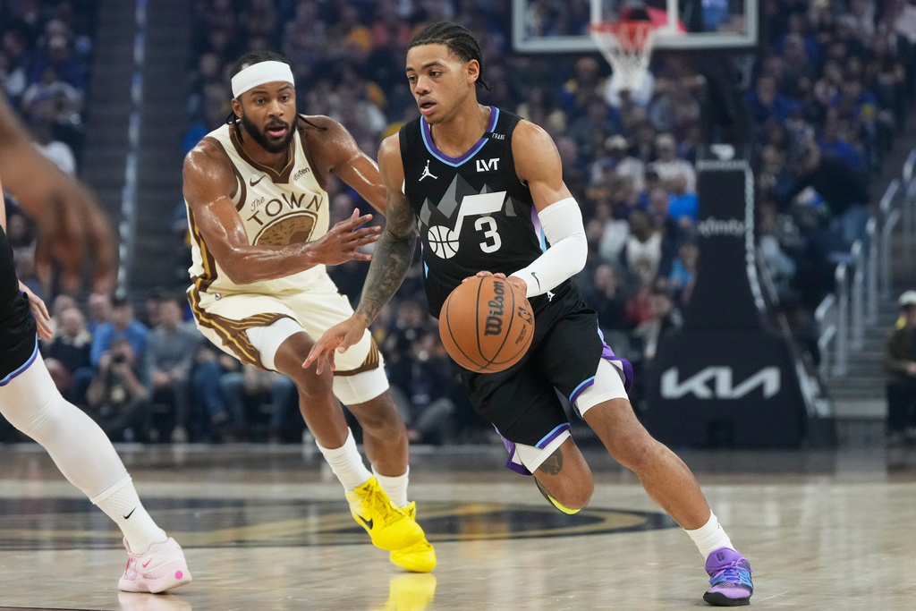 Utah Jazz guard Keyonte George (3) drives to the basket against Golden State Warriors guard Moses Moody during the first half of an NBA basketball game in San Francisco, Monday, Nov. 24, 2025. (AP Photo/Jeff Chiu)