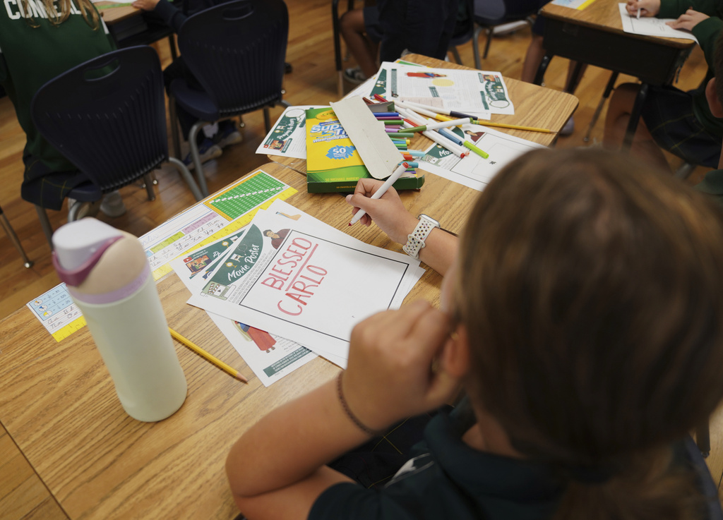 Fifth grade students at St. John Berchmans' school draw pictures of Blessed Carlo Acutis, who will be canonized a saint by Pope Leo XIV, during a class activity on Wednesday, Sept. 3, 2025, in Chicago. (AP Photo/Jessie Wardarski)