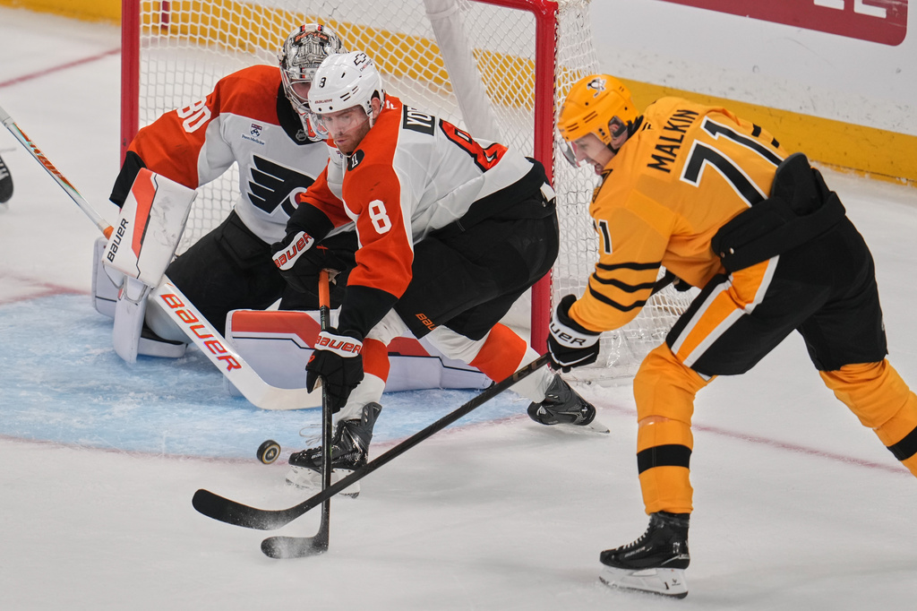 Pittsburgh Penguins' Evgeni Malkin (71) has a shot deflected by Philadelphia Flyers' Cam York (8) in front of Flyers goaltender Dan Vladar (80) during the first period of Game 2 in the first round of the NHL Stanley Cup playoffs in Pittsburgh, Monday, April 20, 2026. (AP Photo/Gene J. Puskar)