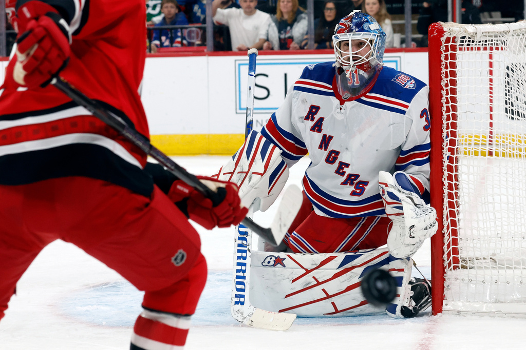 New York Rangers goaltender Igor Shesterkin (31) deflects the puck towards Carolina Hurricanes' Nikolaj Ehlers (27) during the second period of an NHL hockey game in Raleigh, N.C., Monday, Dec. 29, 2025. (AP Photo/Karl DeBlaker)
