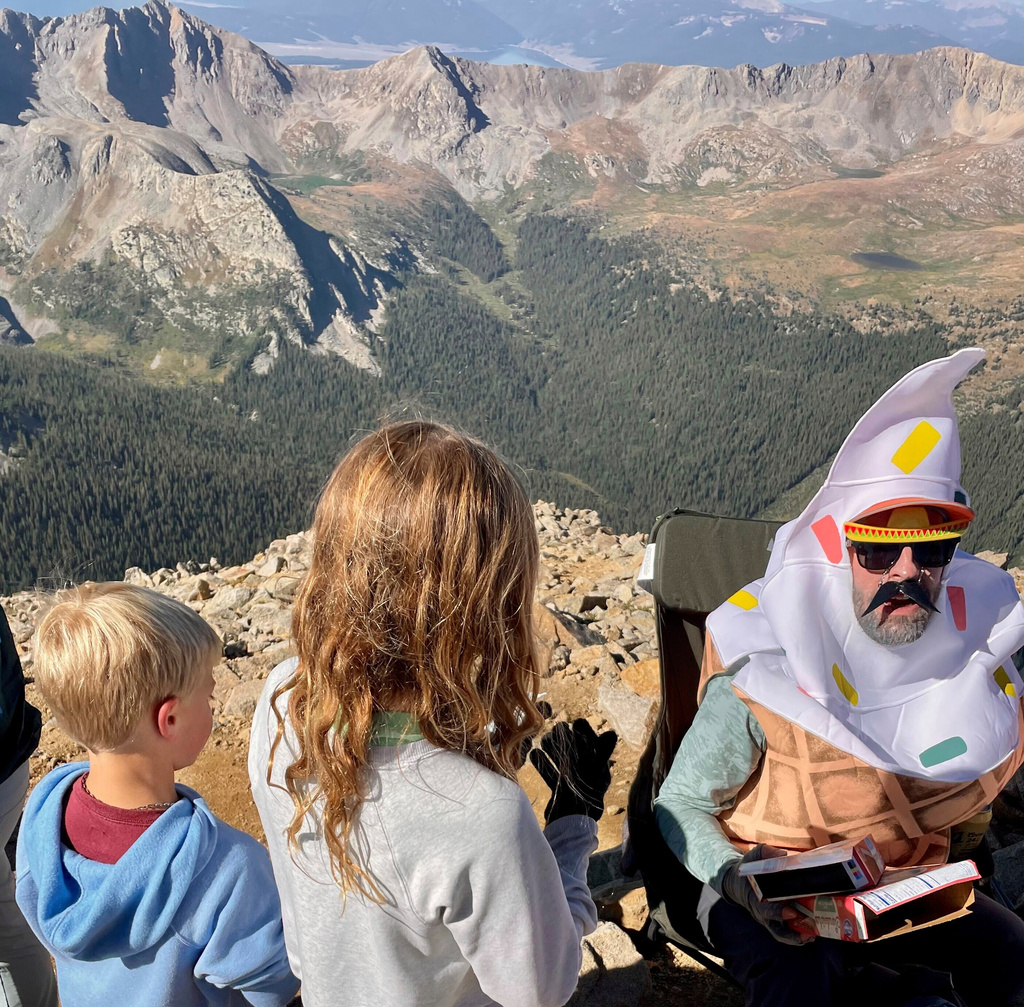 In this photo provided by Christopher Whitestone, a man shares ice cream he carried up Huron Peak packed in dry ice with fellow hikers in Chaffee County, Colo., Sunday, Aug. 31, 2025. (Christopher Whitestone via AP)