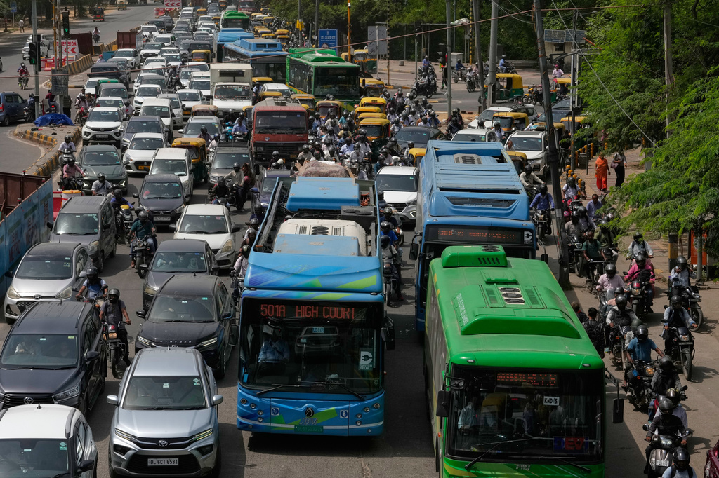 Electric buses move through dense traffic alongside other vehicles and scooters in New Delhi, India, Tuesday, July 14, 2026. (AP Photo/Manish Swarup)