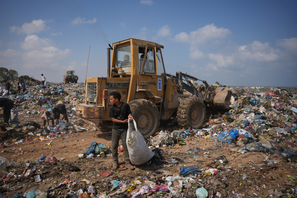Palestinians search through a garbage dump for combustible materials to use as fuel for cooking due to a shortage of cooking gas, in Deir al-Balah, central Gaza Strip, Saturday, Aug. 22, 2026. (AP Photo/Abdel Kareem Hana)