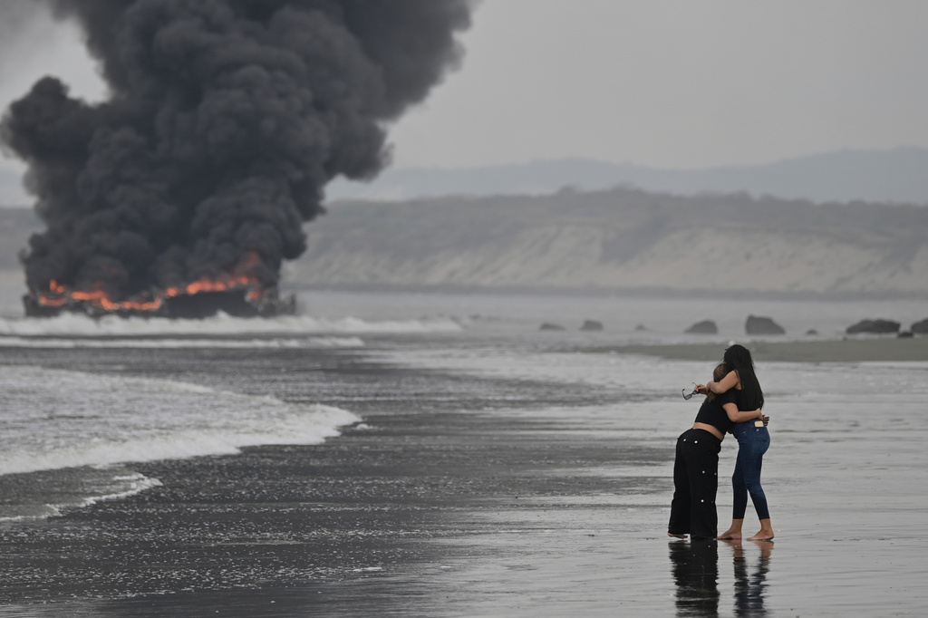 Fishing boats burn in Manta, Ecuador, Saturday, June 6, 2026. (AP Photo/Ariel Ochoa)