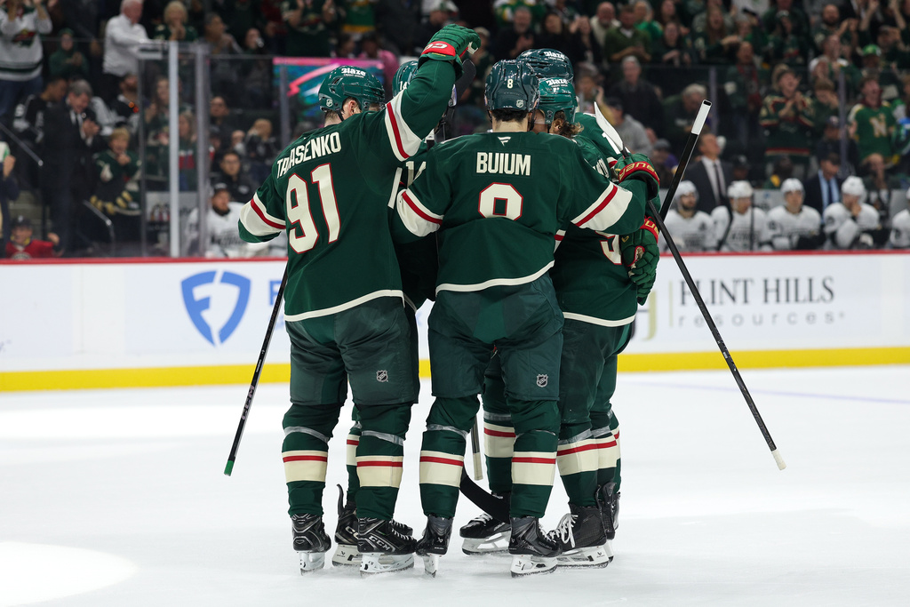 Minnesota Wild left wing Kirill Kaprizov (obscured) is congratulated after his goal against the Los Angeles Kings during the first period of an NHL hockey game Monday, Oct. 13, 2025, in St. Paul, Minn. (AP Photo/Matt Krohn)