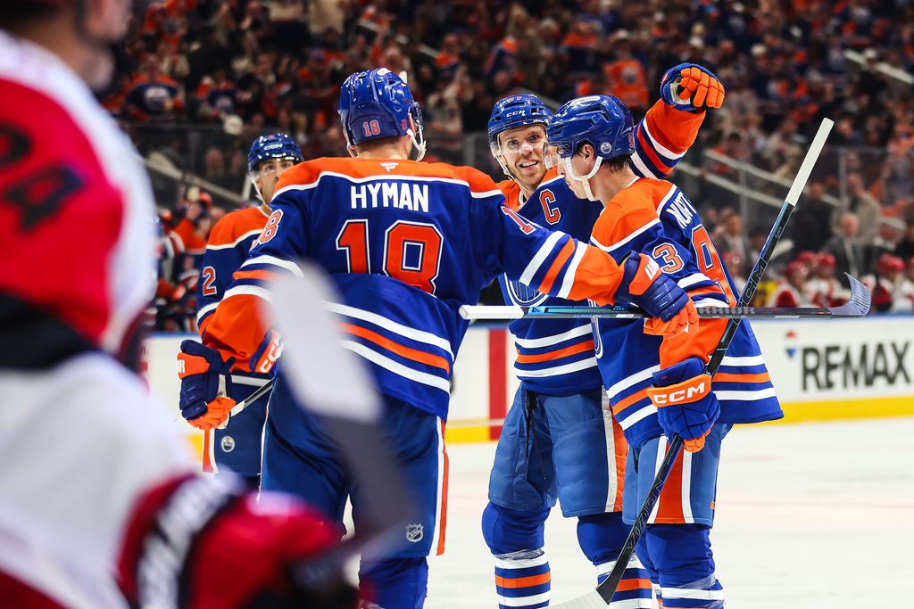 Edmonton Oilers' Zach Hyman (18), Connor McDavid (97) and Ryan Nugent-Hopkins, right, celebrate after Nugent-Hopkins' goal against the Carolina Hurricanes during the second period of an NHL hockey game in Edmonton, Alberta, Thursday, Oct. 22, 2026. (Codie McLachlan/The Canadian Press via AP)