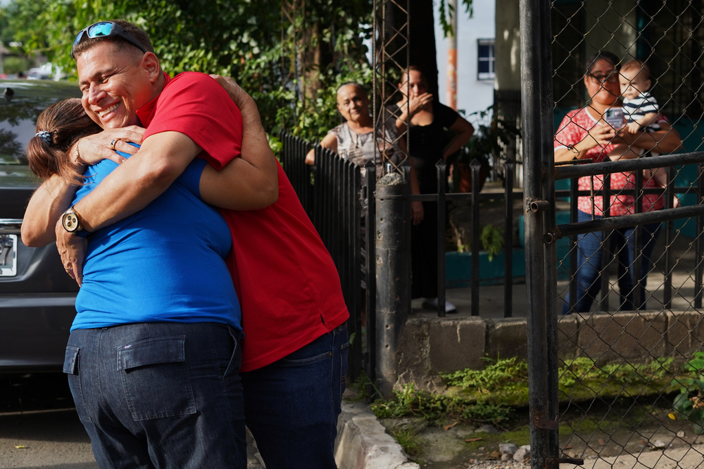 Salvadoran journalist Mario Guevara, right, greets family members after arriving at the home of a relative in Apopa, El Salvador, following his deportation from the United States, Friday, Oct. 3, 2025. (AP Photo/Salvador Melendez)