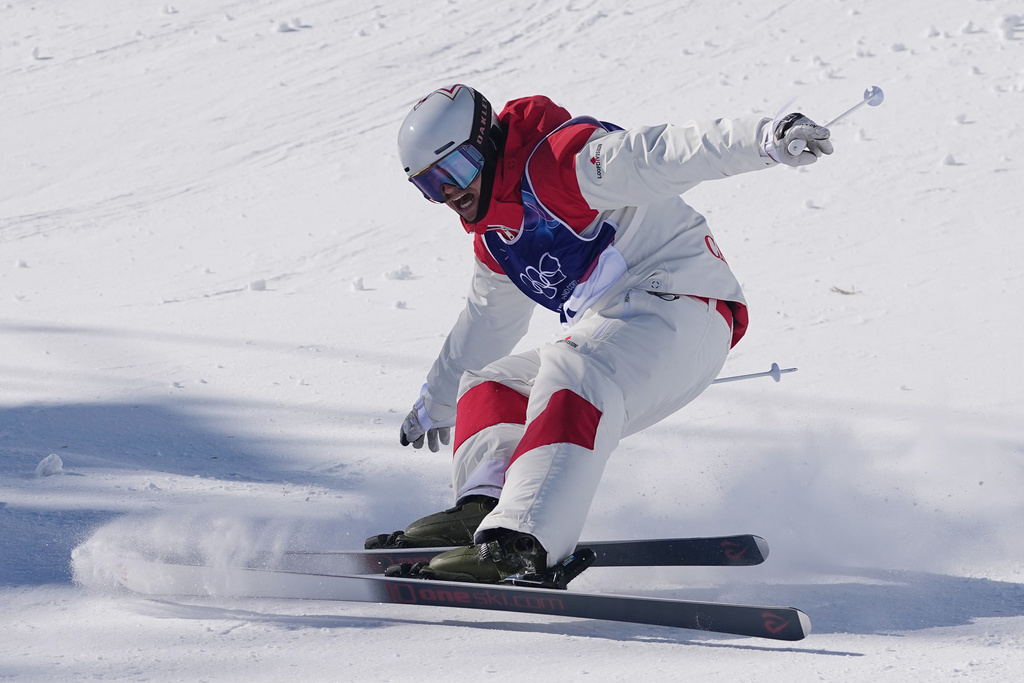 Canada's Mikael Kingsbury (4) celebrates after winning the gold medal during the men's freestyle skiing dual moguls finals at the 2026 Winter Olympics, in Livigno, Italy, Sunday, Feb. 15, 2026. (AP Photo/Gregory Bull)