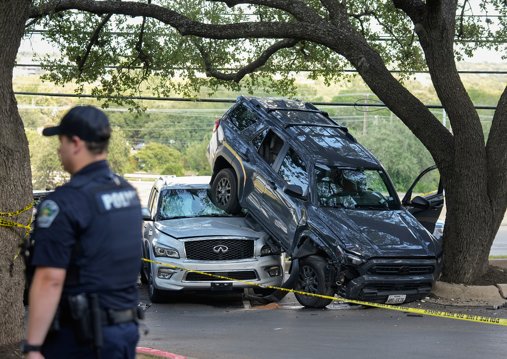Police work at the scene of a multiple-vehicle crash as the stolen 4-Runner driven by the suspect of the Target shooting crashed into a Volkswagen before landing on top of an Infiniti SUV near North Mopac Expressway Service Road and Executive Center Drive in Austin, Texas, Monday, Aug. 11, 2025. (Jay Janner/Austin American-Statesman via AP)