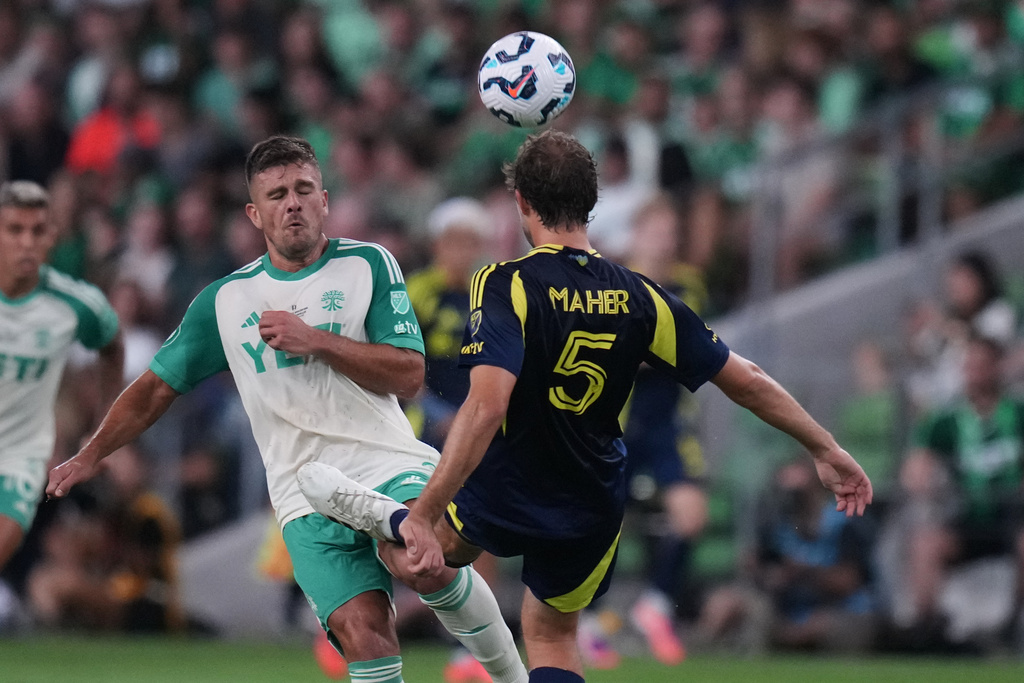 Nashville SC defender Jack Maher (5) kicks the ball and Austin FC forward Diego Rubio (21) during the first half of an U.S. Open Cup final soccer match in Austin, Texas, Wednesday, Oct. 1, 2025. (AP Photo/Eric Gay)