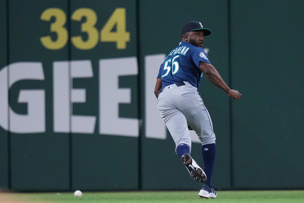 Seattle Mariners outfielder Randy Arozarena (56) chases a double by Texas Rangers designated hitter Joc Pederson, not visible, during the fourth inning of a baseball game Monday, April 6, 2026, in Arlington, Texas. (AP Photo/Julio Cortez)