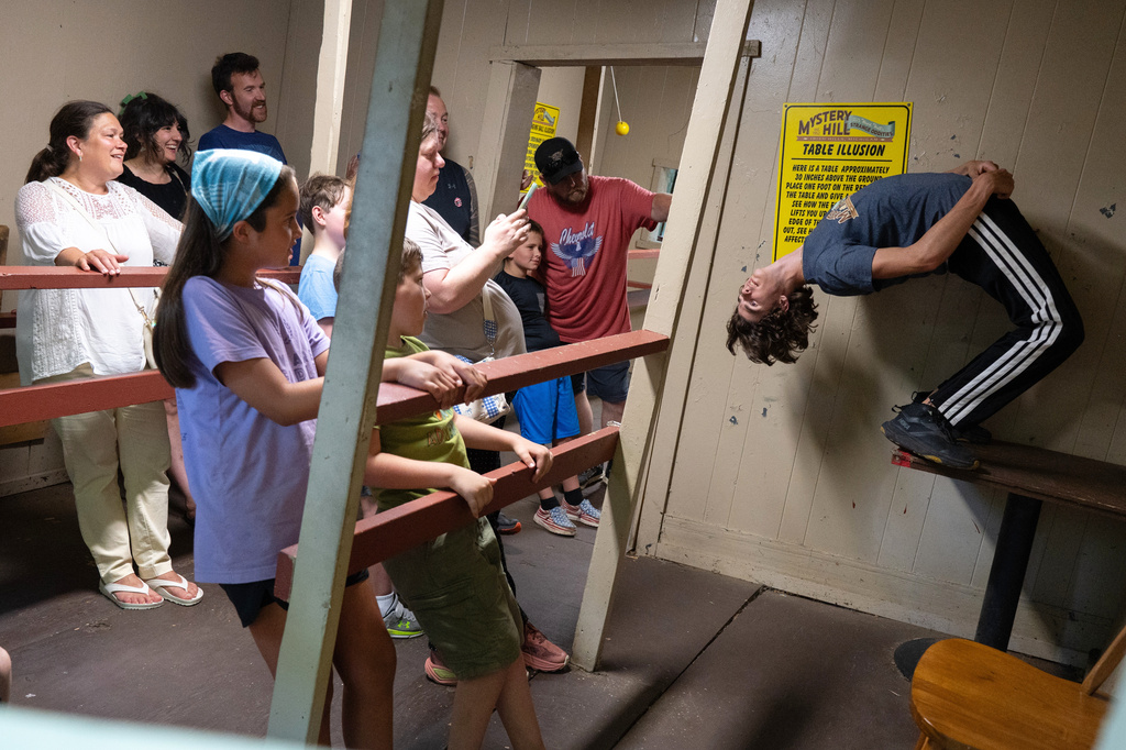 Finn Gerschwiler leads a tour through the gravitational house at Mystery Hill, a roadside attraction in Onsted, Mich., on Saturday, July 18, 2026. (Ella Miller/Bridge Michigan via AP)