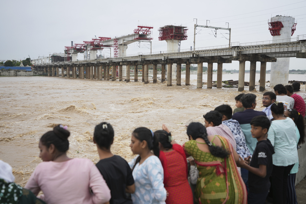 People throng at the Sabarmati riverfront to watch flooded River Sabarmati, in Ahmedabad, India, Sunday, Aug. 24, 2025. (AP Photo/Ajit Solanki)