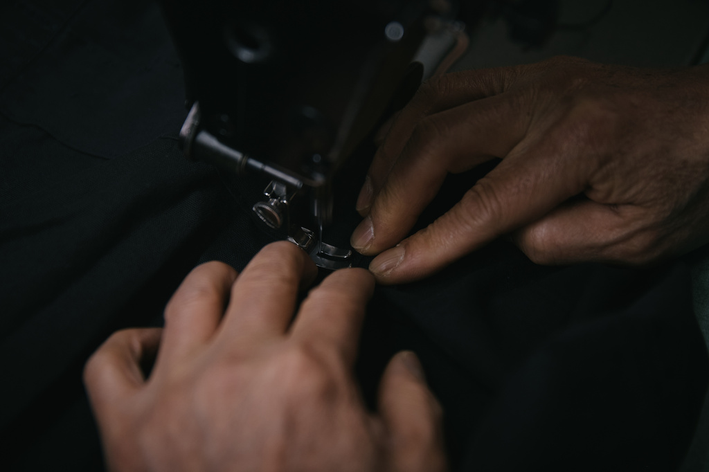 Tailor, Kil Bae, sews a pice inside his shop on Friday, March 27, 2026, in New York. (AP Photo/Andres Kudacki)