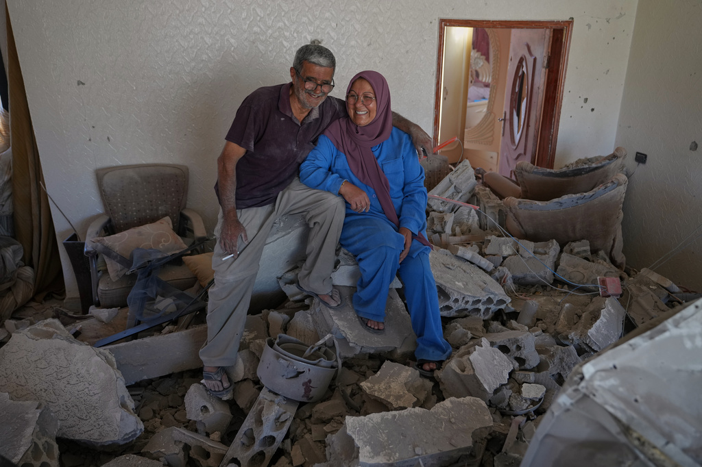 Mahasen Faqih and her husband, Mohammed Sobeih, smile as they sit amid the rubble of their home after returning to it following the Israeli military operation in Zawtar al-Gharbieh, Lebanon, Tuesday, July 28, 2026. (AP Photo/Hassan Ammar)