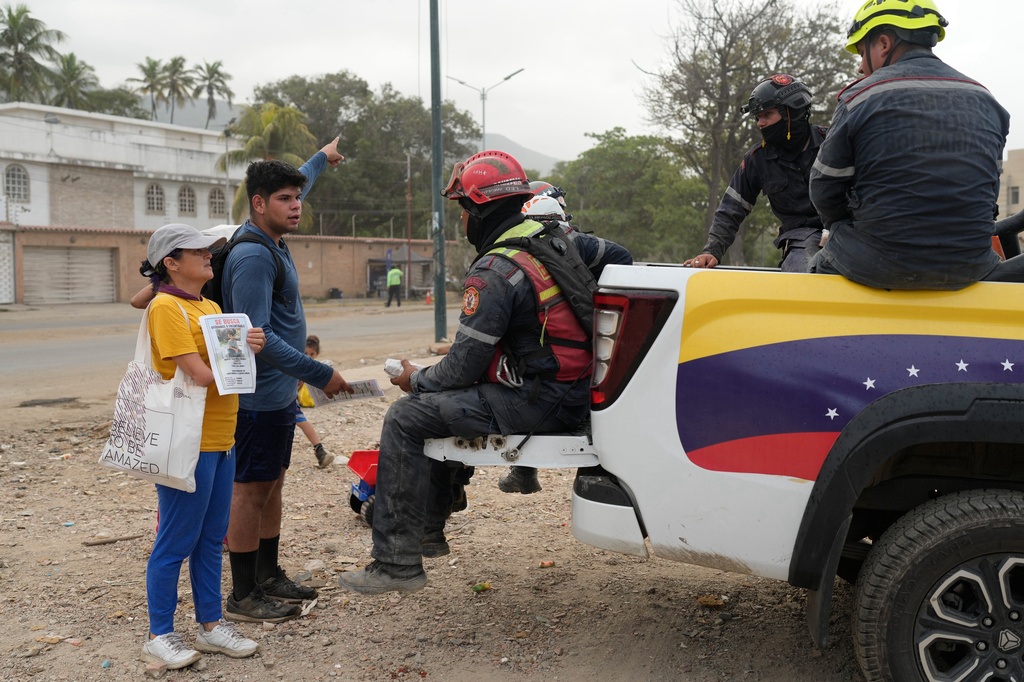 Pedro Gomez asks rescuers for information about his cousin, Andres Molina, who has been missing since the earthquake, in La Guaira, Venezuela, Saturday, Aug. 22, 2026. (AP Photo/Ariana Cubillos)