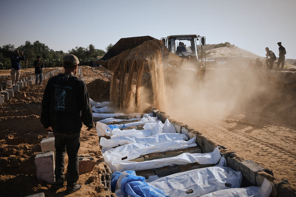 Bodies of unidentified Palestinians returned from Israel as part of the ceasefire deal are buried in Deir al-Balah, Gaza Strip, Sunday, Nov. 23, 2025. (AP Photo/Abdel Kareem Hana)