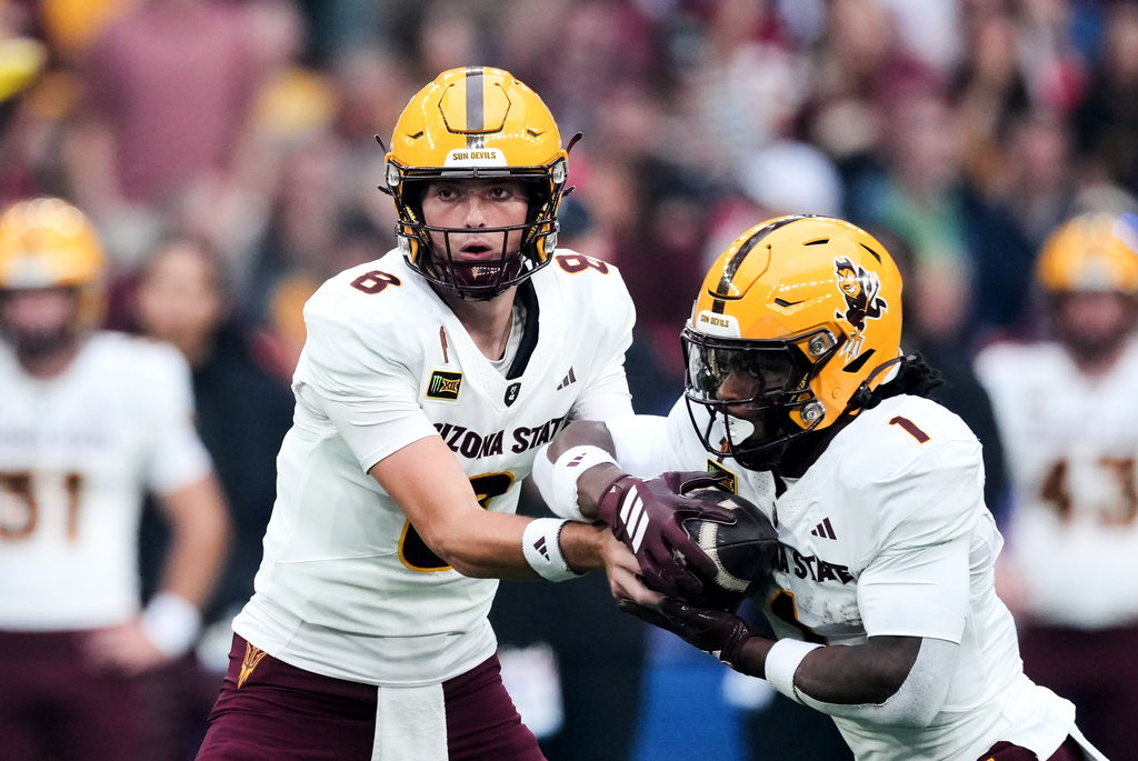 Arizona State Sun quarterback Cutter Boley, left, hands off to running back Kyson Brown (1) during an NCAA college football game against Kansas in London, Saturday, Sept. 19, 2026. (AP Photo/Dave Shopland)