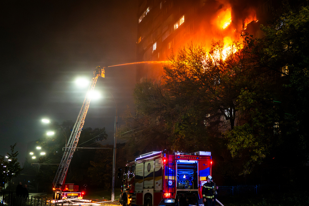 Emergency services personnel work to extinguish a fire following a Russian attack in Kyiv, Ukraine, Friday, Oct. 10, 2025. (AP Photo/Dan Bashakov)
