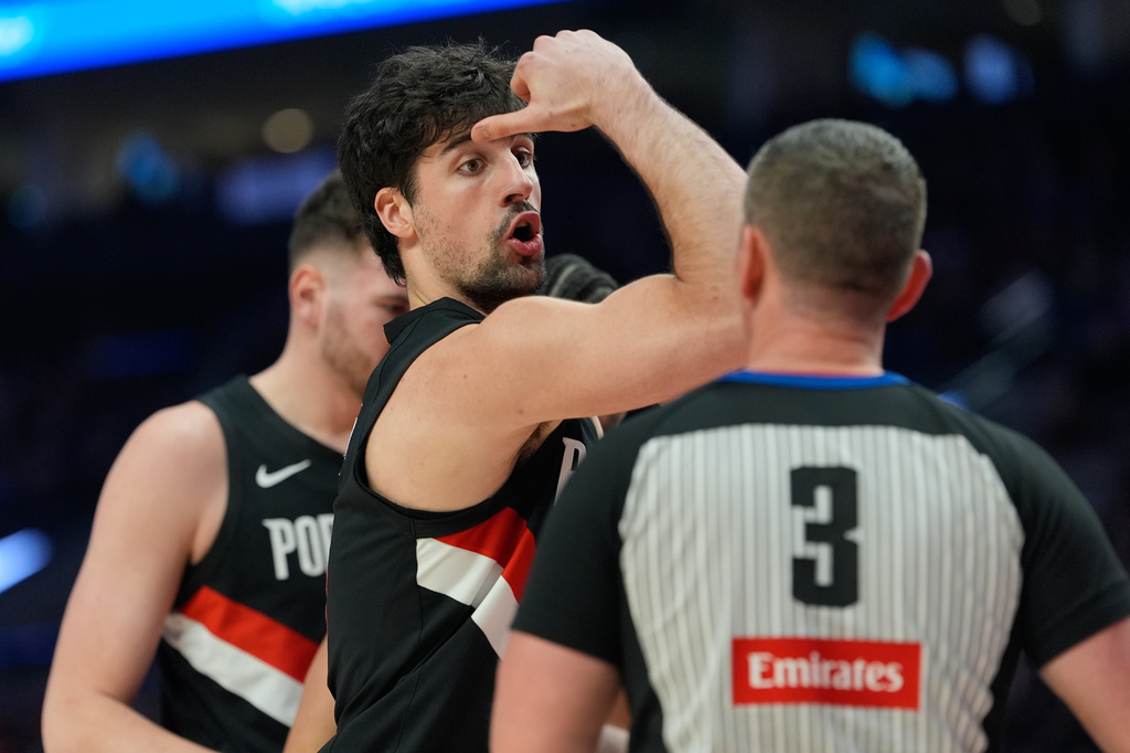 Portland Trail Blazers forward Deni Avdija talks with referee Nick Buchert (3) during the first half of an NBA basketball game against the Dallas Mavericks, Friday, March 27, 2026, in Portland, Ore. (AP Photo/Jenny Kane)
