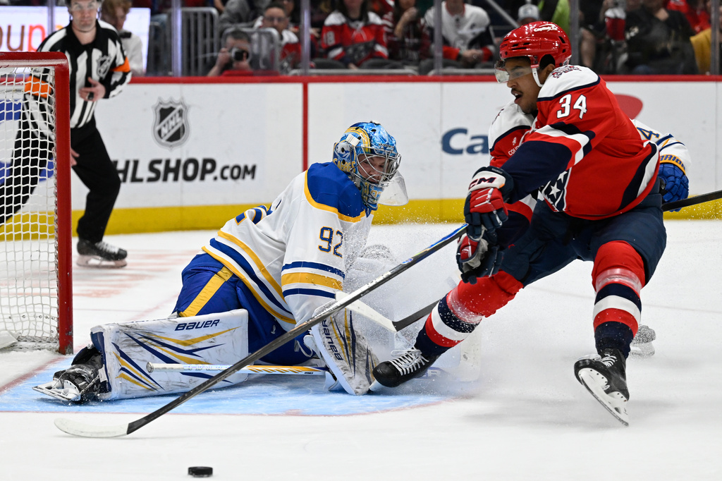 Washington Capitals center Justin Sourdif (34) reaches for a rebound off of Buffalo Sabres goaltender Colten Ellis during the first period of an NHL hockey game, Saturday, April 4, 2026, in Washington. (AP Photo/John McDonnell)