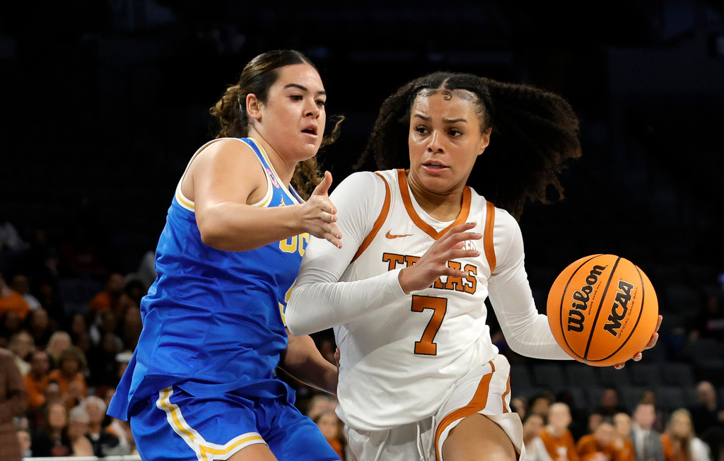 Texas guard Jordan Lee (7) drives against UCLA guard Charlisse Leger-Walker (5) during the first half of an NCAA college basketball game in the Players Era tournament Wednesday, Nov. 26, 2025, in Las Vegas. (AP Photo/Steve Marcus)
